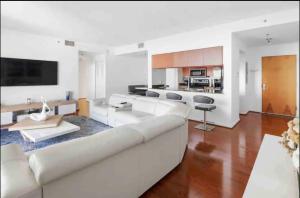 a living room with a white couch and a kitchen at Stunning 2Br Condo brickell-Waterviews-FreeParking in Miami