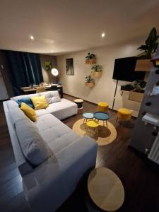 sala de estar con sofá blanco y almohadas amarillas en Maison cosy - 10min Nantes, gare et aéroport en Rezé