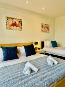 a bedroom with two beds with towels on them at Burton Manor-Sleeps 16 in Burton Town Centre in Burton upon Trent