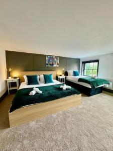 Habitación de hotel con 2 camas con sábanas verdes en Burton Manor-Sleeps 16 in Burton Town Centre en Burton upon Trent