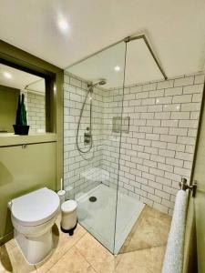 a bathroom with a toilet and a glass shower at Burton Manor-Sleeps 16 in Burton Town Centre in Burton upon Trent