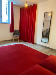 シャブリにあるLe Cristallin gîte plein coeur de Chablisの赤いカーテンと鏡と赤い敷物が備わる部屋