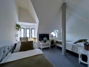 1 dormitorio con 2 camas, sofá y TV en Bella Casa, en Mnichovo Hradiště