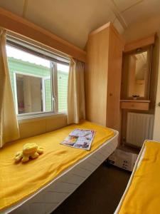 uma cama com um urso de peluche sentado em cima dela em Houseboat Praha Marina 1 em Praga