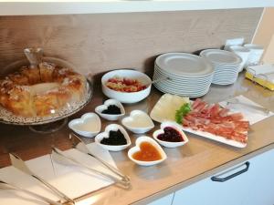 una mesa cubierta con platos y tazones de comida en AFFITTACAMERE B&B MERCEDES, en Romallo
