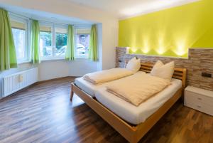 sypialnia z łóżkiem i żółtą ścianą w obiekcie Appartments Zell am See w mieście Zell am See