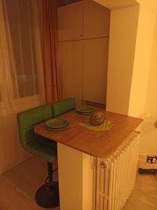 a kitchen with a table and a green chair at Ame Farmec in Cluj-Napoca