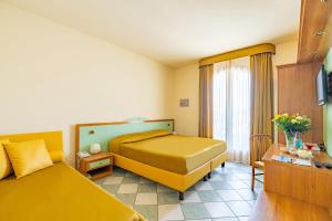 a hotel room with two beds and a window at Hotel Villa Elena in Tortoreto Lido