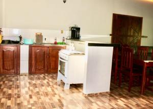 a kitchen with a white stove top oven next to a table at CASA DE TEMPORADA MARCONE LIMA in Barreirinhas