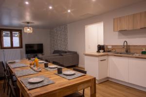 eine Küche und ein Wohnzimmer mit einem Holztisch in der Unterkunft Tignes Appartement 140 m2 pour 08-10 personnes in Tignes