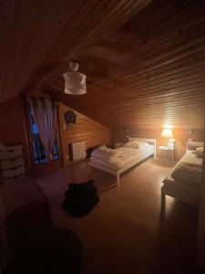 a bedroom with two beds in a wooden room at Chalet des 2 lacs in Xonrupt-Longemer