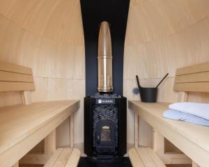 una estufa de leña en una sauna con dos bancos en Konglehytta, en Strandlykkja