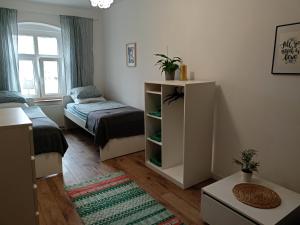 a small room with a bed and a table at Lemuria Hostel Szkolna centrum in Legnica