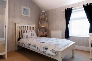 1 dormitorio con 1 cama con marco blanco en The Bell Lodge en Sandown