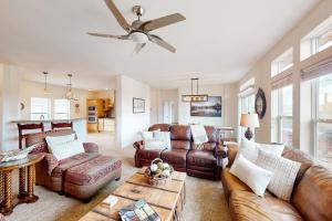 a living room with leather furniture and a ceiling fan at Cottonwood Pass Retreat in Gypsum