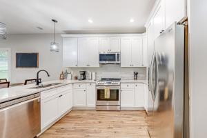 亞特蘭大的住宿－Grove Park Place - Unit A，厨房配有白色橱柜和不锈钢冰箱