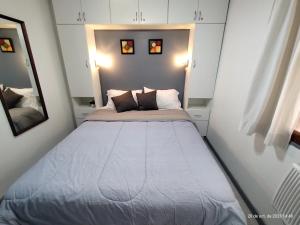 un grande letto in una piccola stanza con due cuscini di Depto super cool en pleno centro de Mendoza a Mendoza