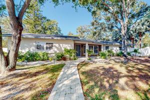 a home with a pathway in front of a yard at Seminole's Secret in Redington Shores
