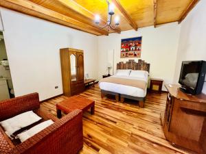 a bedroom with a bed and a tv and a couch at Hotel Jireh in San Pedro de Atacama