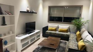 a living room with a couch and a television at Studio de luxe coté de l aireport Mohamed 5 casa "Location de voitures "www dwarscars com" in Nouaseur