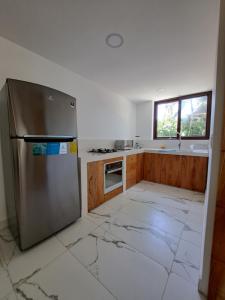 eine Küche mit einem Kühlschrank aus Edelstahl in der Unterkunft Spondylus Lodge in Ayampe