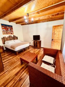 a bedroom with a bed and a couch and a television at Hotel Jireh in San Pedro de Atacama