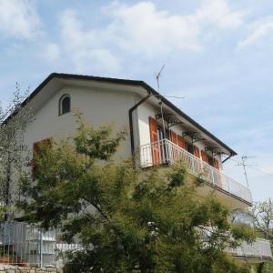 a white building with a balcony on top of it at Appartamento Elide in Bolano