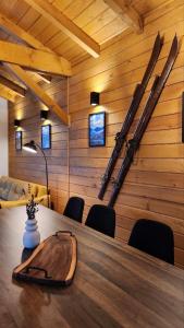 een kamer met een tafel met ski's aan de muur bij HillVill in Govedartsi