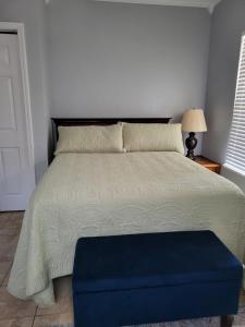 ein Schlafzimmer mit einem Bett mit einem blauen Ottomanen in der Unterkunft Old Biloxi Rest, Relax and Enjoy the Beach in Biloxi