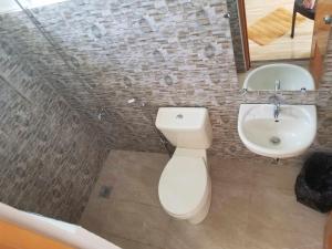 a bathroom with a white toilet and a sink at JSS PENSION HOUSE in Can-asujan