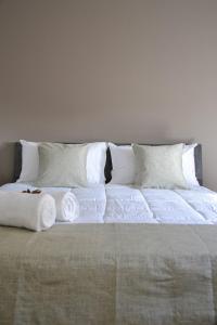 un grande letto con lenzuola e cuscini bianchi di Ca' dela Stazion a Verona
