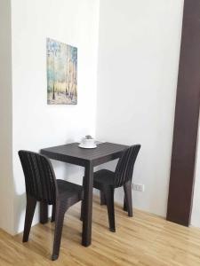 uma mesa preta e duas cadeiras num quarto em JSS PENSION HOUSE 