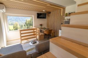 ein Wohnzimmer mit einem Sofa, einem Schreibtisch und einem Fenster in der Unterkunft Panorama 13 in Tolmin