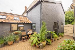 a house with a courtyard with plants in front of it at Most romantic cottage in Suffolk - Number Four in Framlingham