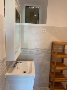 uma casa de banho com um lavatório e um espelho em Gite tout confort - Vexin - Val d'Oise em Frémainville