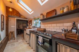 a kitchen with a stove and a counter top at Most romantic cottage in Suffolk - Number Four in Framlingham