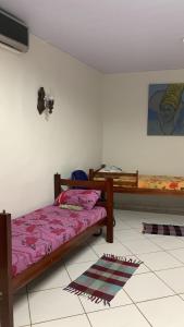a bedroom with two beds and a tv on the wall at HOSTEL YA DUDU E BISTRO in Cuiabá