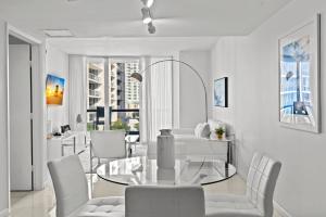 Un comedor con una mesa de cristal y sillas blancas. en Luxury 1 BR Condo W Icon Brickell-Waterviews, en Miami 19 fotos más