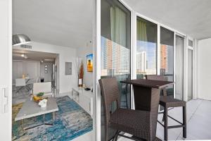 a living room with a table and chairs on a balcony at Luxury 1 BR Condo W Icon Brickell-Waterviews in Miami