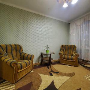 uma sala de estar com duas cadeiras e uma mesa em Квартира-apartament em Tiraspol
