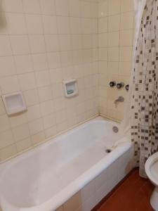 bagno con vasca bianca e servizi igienici di Depto casique 2pax a Necochea