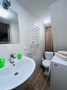 uma casa de banho com um lavatório branco e um WC. em Апартаменты на Троицкой em Odessa