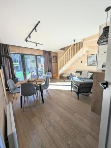 a living room with a table and chairs and a staircase at Babia Ostoja - domek z balią i sauną in Zawoja +27 photos