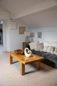 sala de estar con sofá y mesa de centro de madera. en The Amazing Attic Apartment, en Skipton