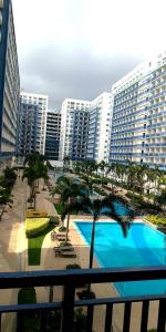 a view of a resort with a pool and buildings at Sea Residences - Manila Pasay near MOA by Ipe in Manila