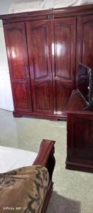 a wooden cabinet and a chair in a room at Appartement à ALHOCEIMA in Al Hoceïma