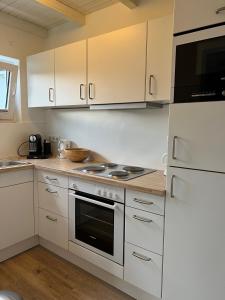 a kitchen with white cabinets and a stove top oven at Landhaus 918 in Koosbüsch