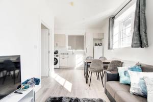 ein Wohnzimmer und eine Küche mit einem Sofa und einem Tisch in der Unterkunft 2 bedroom apartment with large rooms and Wi-Fi in London
