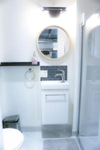a white bathroom with a sink and a mirror at Cozy apartment in Ahuntsic with Free Parking and near metro station in Montreal