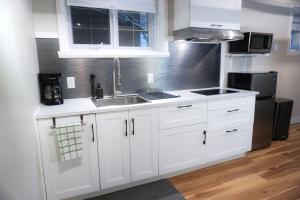 a kitchen with white cabinets and a sink at Cozy apartment in Ahuntsic with Free Parking and near metro station in Montreal